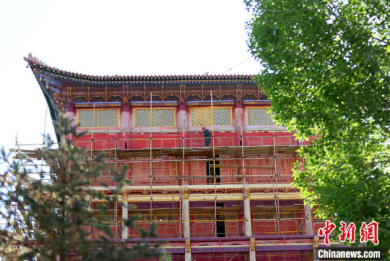 圖為5月上旬，甘肅山丹縣大佛寺內(nèi)，工作人員對(duì)古建筑大雄寶殿進(jìn)行修繕。 中新社記者 高展 攝