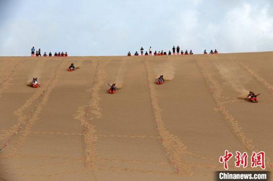 6月13日，敦煌鳴沙山月牙泉景區(qū)舉辦滑沙比賽。　張曉亮 攝