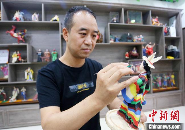 圖為安秋平正在創(chuàng)作代表隴南文縣民俗的《白馬人》作品?！「哒?攝