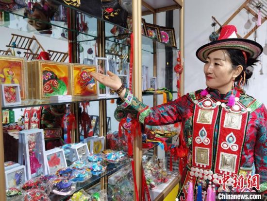 圖為身著民族服飾的隴原巧手展示手工藝品。(資料圖) 徐雪 攝