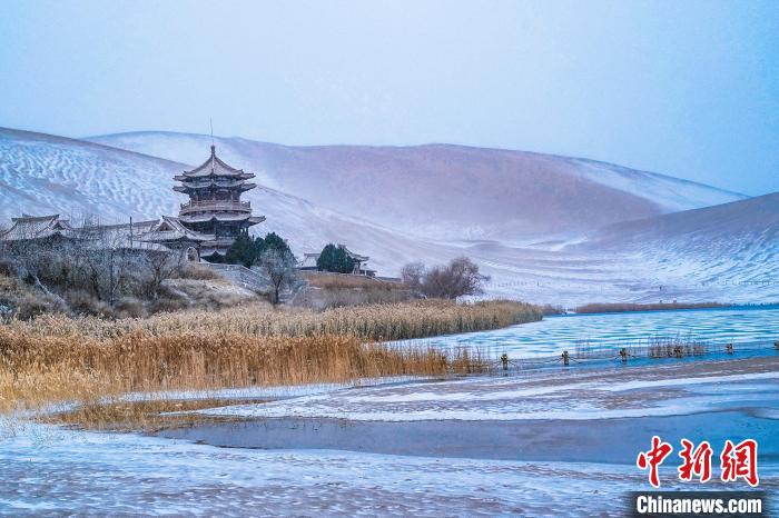 2021年11月28日，雪落鳴沙山月牙泉景區(qū)?！⊥醣筱y 攝