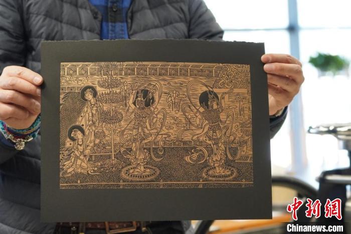 圖為手工書藝人展示敦煌雕版壁畫印刷品?！【琶赖┰?　攝