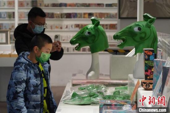 圖為“神馬來了”銅奔馬頭套吸引參觀者駐足?！【琶赖┰?攝
