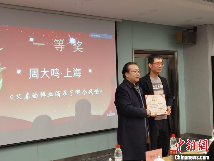 圖為作家、西北師范大學(xué)新聞與傳媒學(xué)院院長徐兆壽頒發(fā)一等獎證書，代領(lǐng)獎?wù)呱吓_領(lǐng)獎?！钅?攝