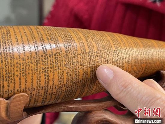 圖為長(zhǎng)約二十公分的長(zhǎng)條葫蘆雕刻佛教經(jīng)文作品?！堟?攝