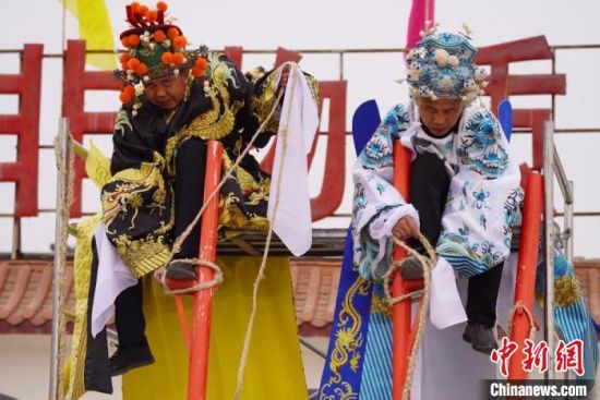 圖為“苦水高高蹺”表演者通過(guò)麻繩將腳固定在腳踏板，并在腿部纏繞六七圈?！【琶赖┰?攝