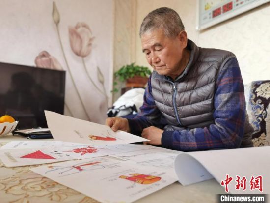 圖為陸鵬飛向記者展示多年帶隊(duì)的手寫筆記?！堟?攝