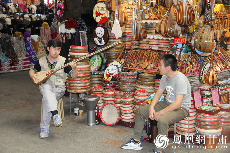 烏魯木齊二道橋巴扎內(nèi)，店主正在向客人展示樂器。楊文遠 攝