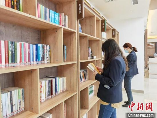 圖為在甘肅公航旅建設集團有限公司的職工書屋，職工挑選書籍?！⌒煅?攝
