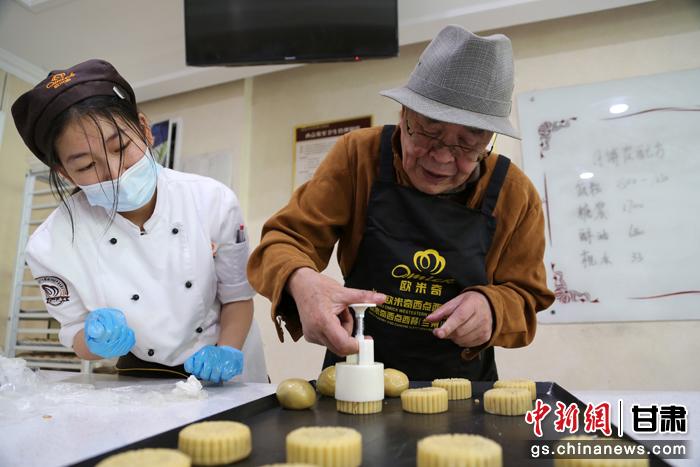 當(dāng)日，受邀參加活動的臺胞臺屬代表、兩岸婚姻及子女、在甘臺商代表等歡聚一堂。圖為77歲的在甘臺胞潘天鑒制作月餅。九美旦增 攝