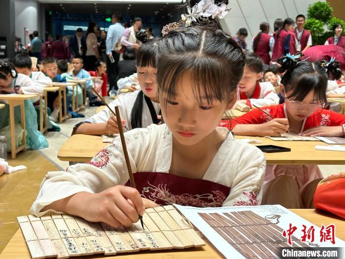 圖為小朋友在甘肅簡牘博物館練習(xí)書法?！≈行律缬浾?戴文昌 攝