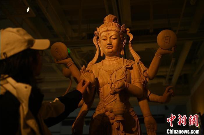 圖為季茂杰觀察自己創(chuàng)作的敦煌木雕。李亞龍 攝</p>
<p>