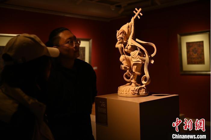 圖為季茂杰向參觀者介紹自己創(chuàng)作敦煌木雕的過程。李亞龍 攝</p>
<p>