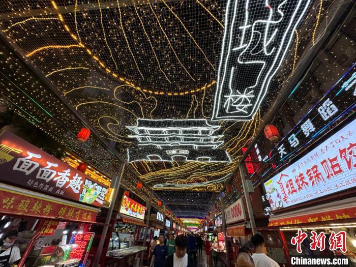 圖為明清街夜市燈光點亮具有武威文化元素的“涼州古城門”彩燈。　戴文昌 攝</p><p>