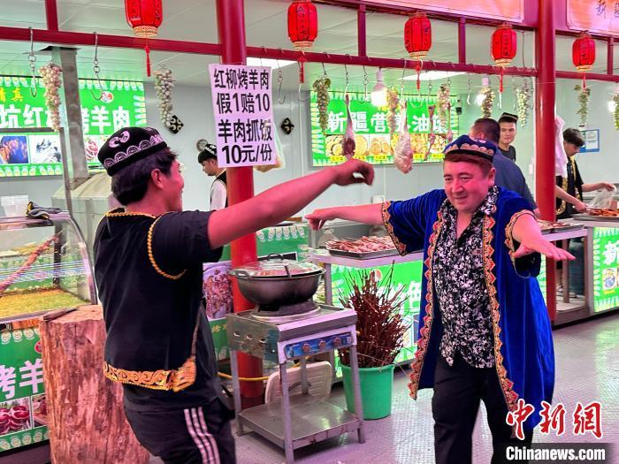圖為餐飲經(jīng)營者在“西涼不夜城”跳起舞蹈引客?！〈魑牟?攝</p><p>